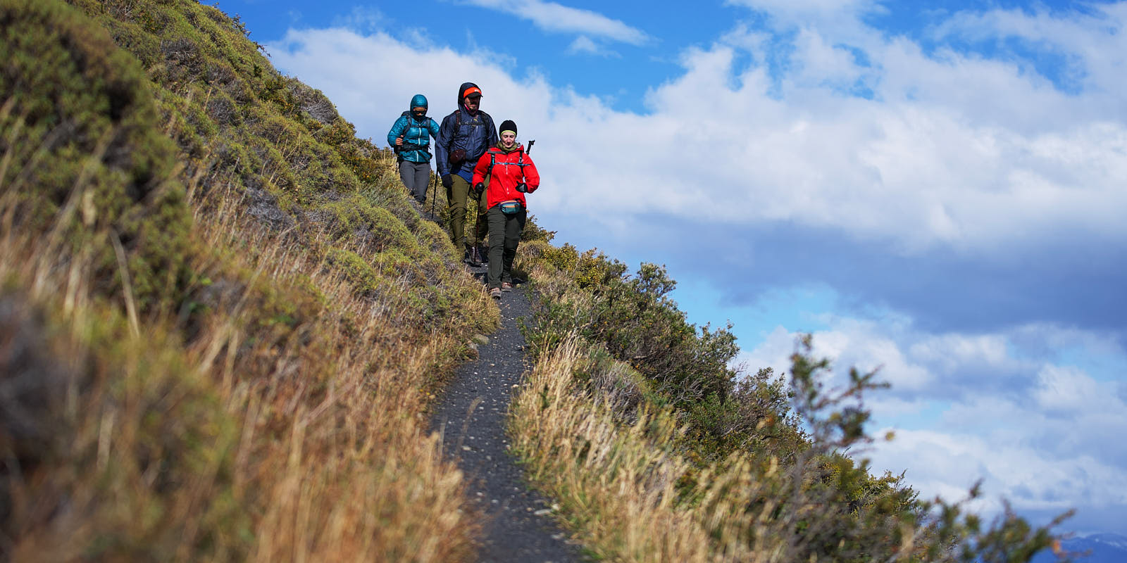 A narrow trail is no place to dig around in a backpack for your camera Hikers descend a trail in the mountains